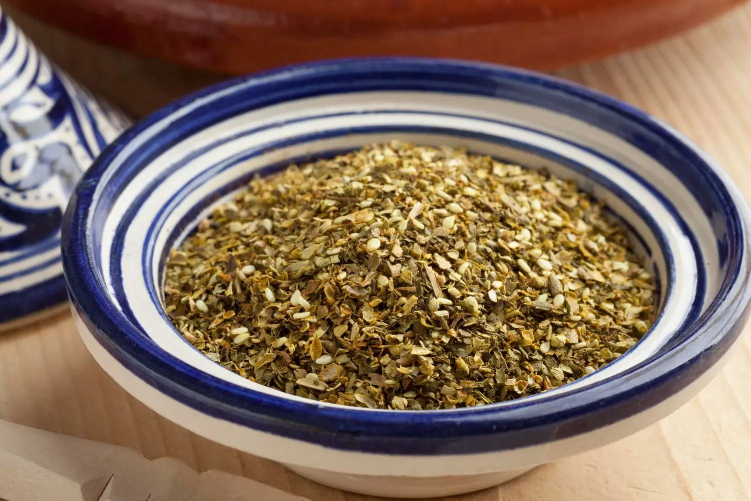Tigela de cerâmica azul e branca contendo za'atar, uma mistura de especiarias do Oriente Médio.
